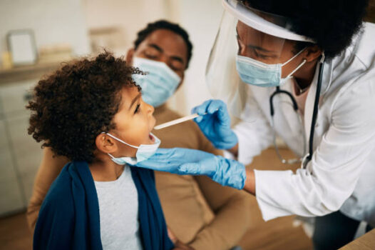 NFP doctor examining the throat of a small black boy on a Sick Visit at North Florida Pediatrics Lake city during RSV and Flue season 2025