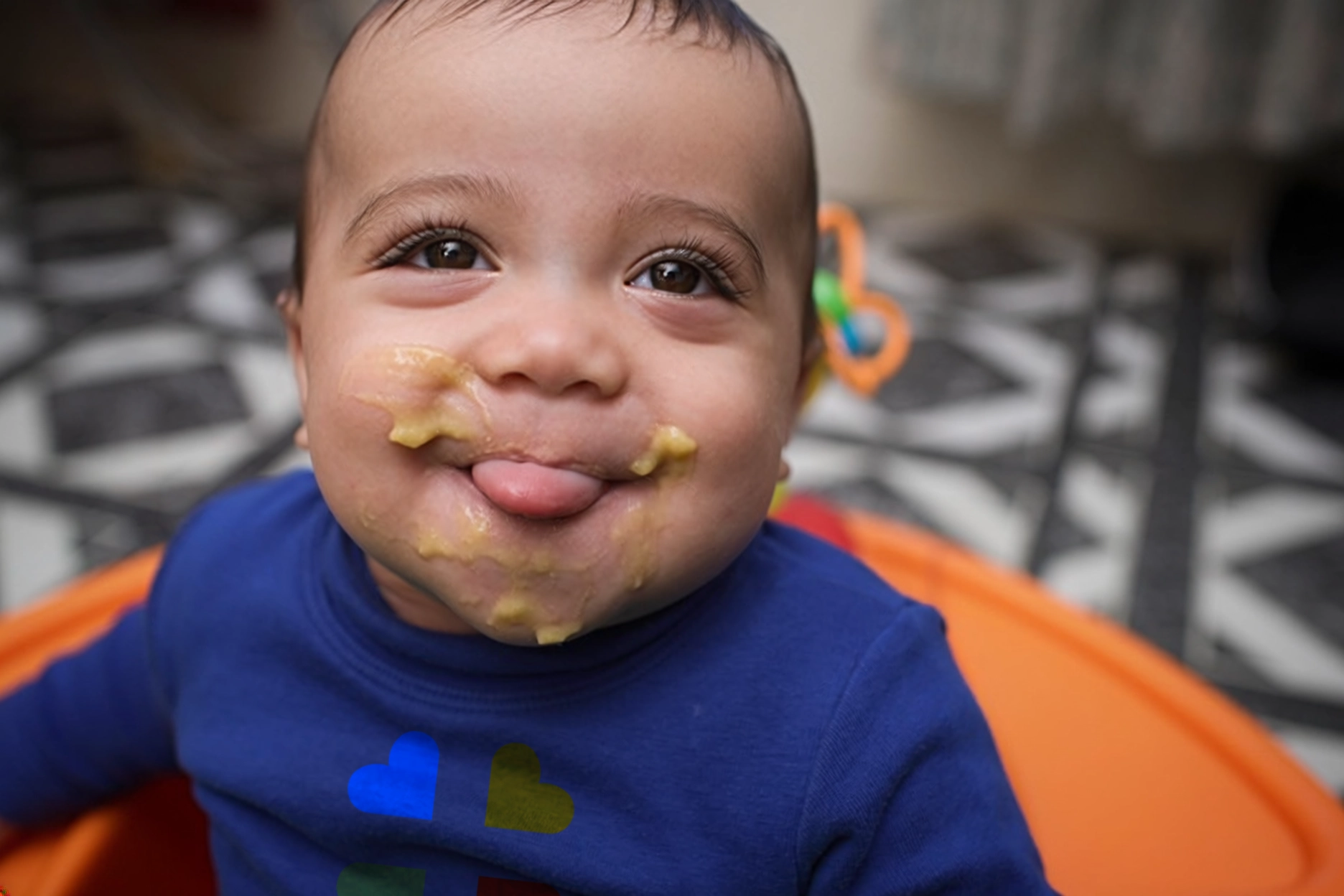 NFP-AGES N STAGES- 4-6 months smiling infant sitting in an orange high chair