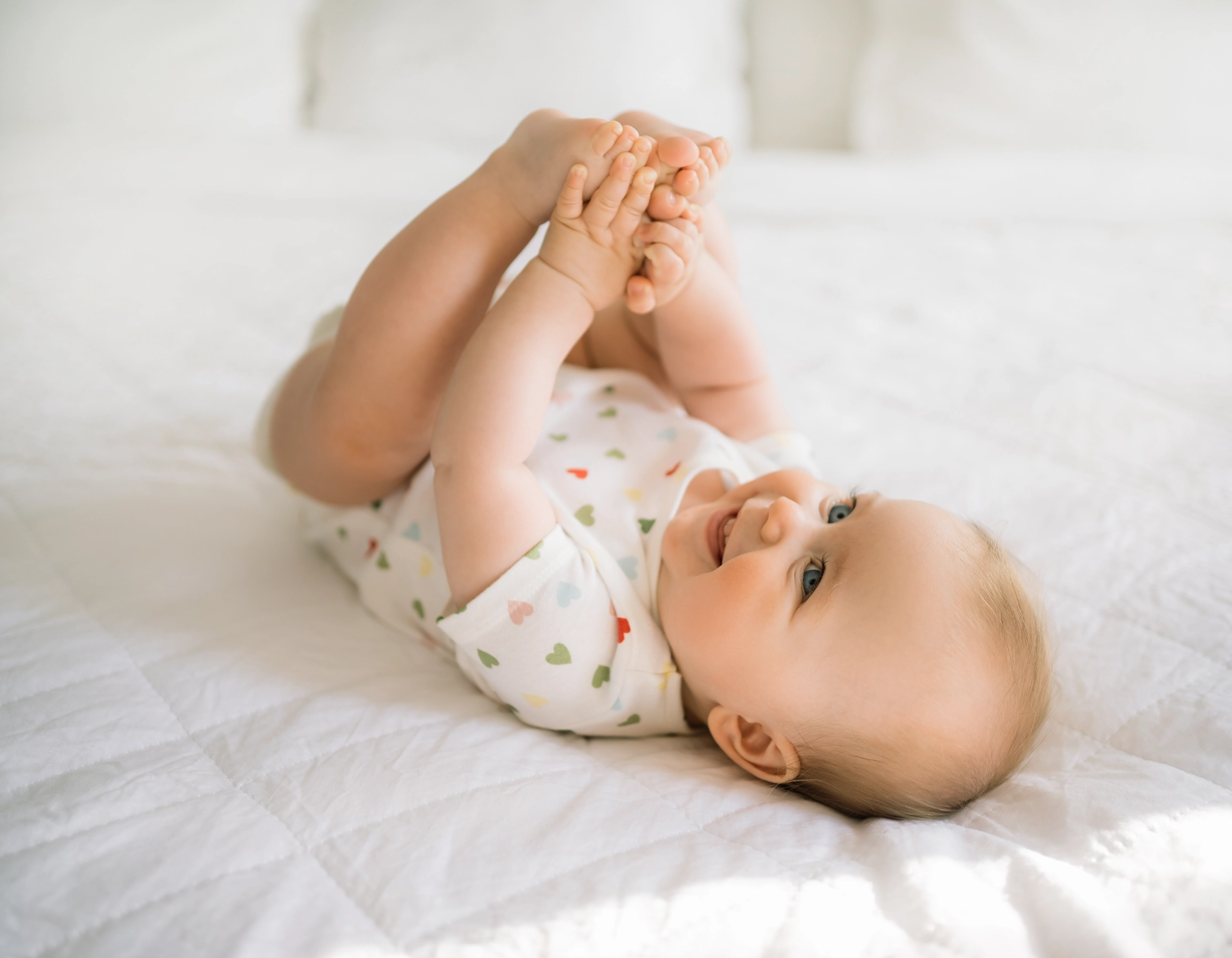 NFP- AGES N STAGES _ a happy infant lying on their back