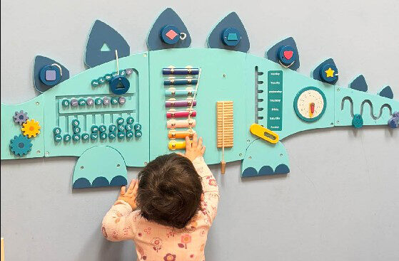 kid playing with a dino wall art