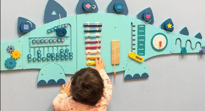 kid playing with a dino wall art