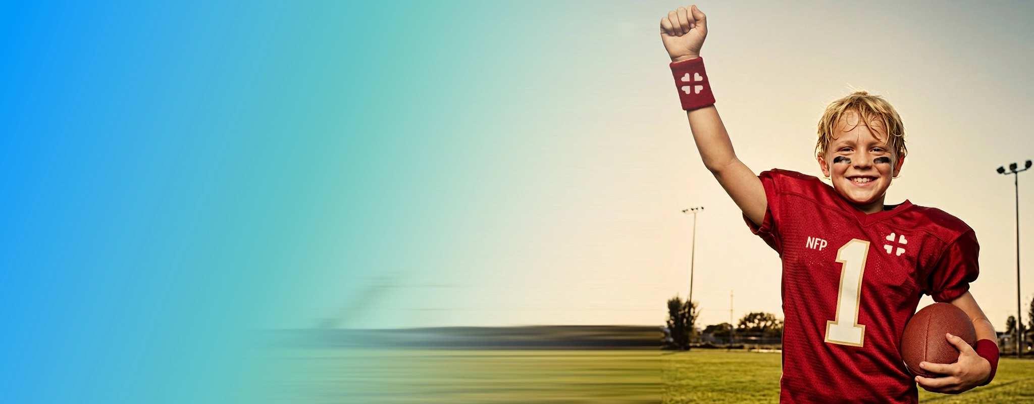 2026 Sport Physical Exams Includes a Free E K G exam-The picture shows a smiling, blondie teeneager, football player raising his right arm as a sign of victory, as he wears a red uniform withthe number one on it.